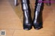 A close up of a pair of black boots on a wooden floor.