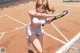 A woman holding a tennis racquet on a tennis court.