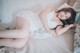 A woman laying on a bed in a white lingerie.