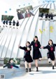 A group of young women in school uniforms holding hands.