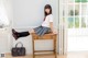 A woman sitting on top of a wooden table.