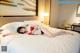 A woman laying on a bed in a hotel room.