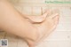 A woman's bare feet on a tiled floor. 